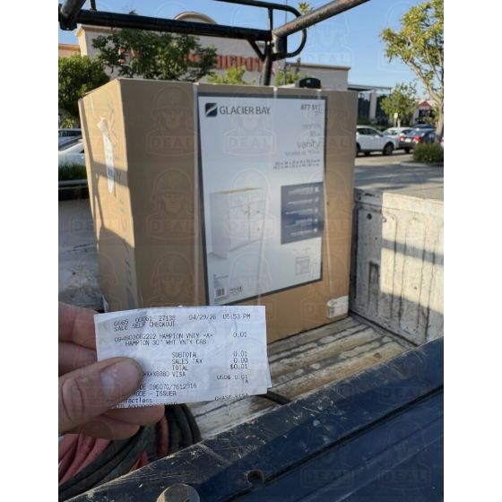 Boxed Glacier Bay Hampton 30 inch white vanity cabinet loaded in a pickup truck bed outside a Home Depot.
