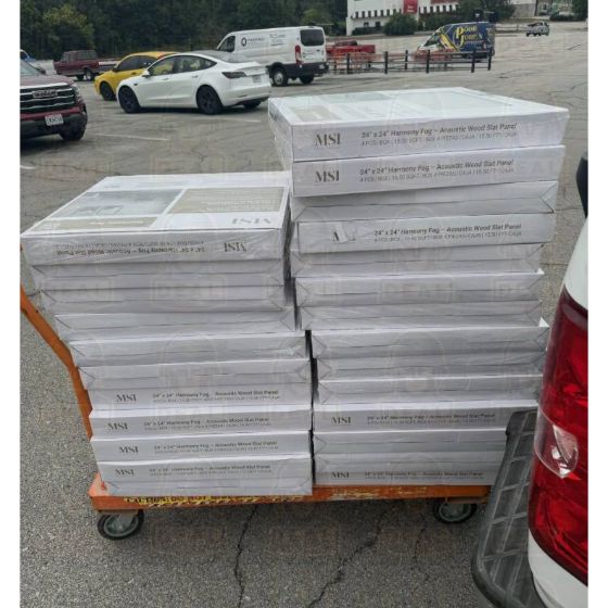 Home Depot flat cart stacked with boxed MSI Harmony Fog acoustic wood slat wall panels in a store parking lot.