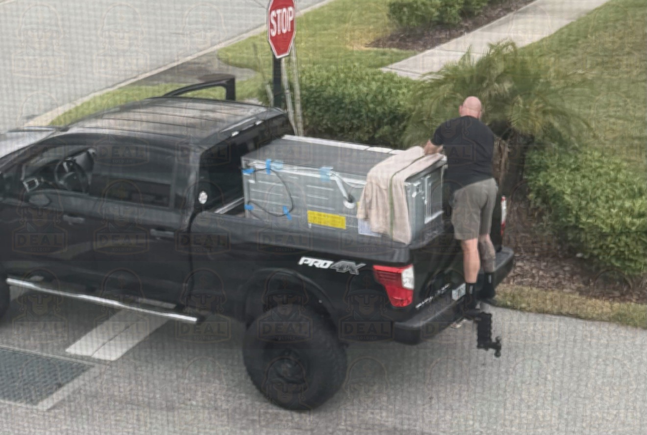 Loading the discounted refrigerator into a pickup truck